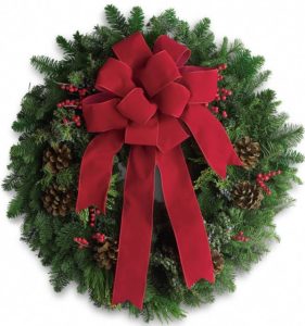 fresh evergreen wreath is adorned with a traditional red velvet bow for a classic Christmas welcoming. Fragrant, for indoor or outdoor decor.