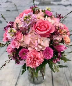Pretty pink roses, carnations, hydrangea and assorted pink tone flowers in a delicate vase design