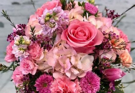 Pretty pink roses, carnations, hydrangea and assorted pink tone flowers in a delicate vase design.