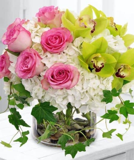 Graceful roses, hydrangea and Cymbidium Orchids are a flower lovers dream with this contemporary garden styling in clear glass vase