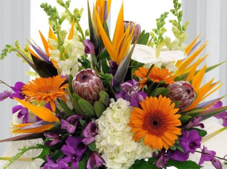 This is the ultimate 'take me away' bouquet with a gorgeous combination of tropical and garden blooms...accented with a treasured touch of seashells. The orange, purple and white theme are invigorating and attention getting.
