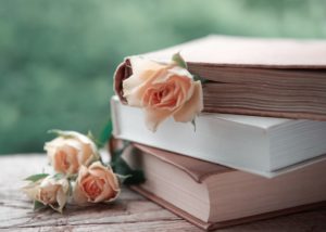 3 books on top of each other with small flowers