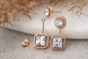 Golden earrings isolated, with white crystals and diamonds. Beautiful earrings on white background. Women accessories