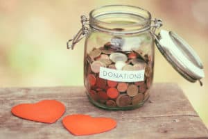 Loving donations jar with coins and hearts