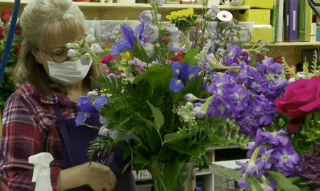 Floral designer putting together bouquet of flowers
