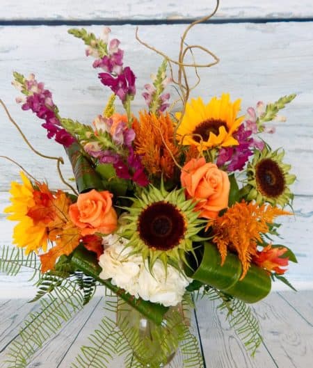 Charming and beautiful, our Farmers' Daughter bouquet is everything she would love from a walk in the fields! Our farm-to-vase selection of bold Sunflowers, Snapdragons, Roses, and Hydrangea are designed with a wildness of botanical fall textures and colors. A beautiful wildflower-style arrangement can be your new eclectic seasonal favorite.